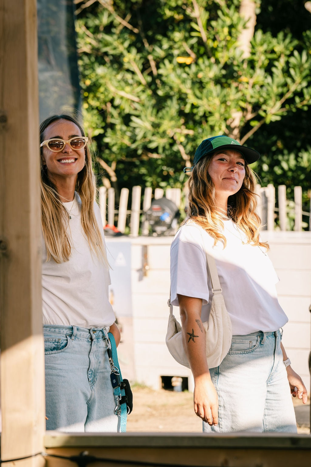 Two women smiling wearing white t-shirts